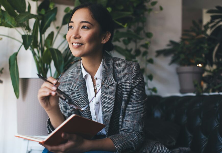 , happy Asian journalist with notepad planning