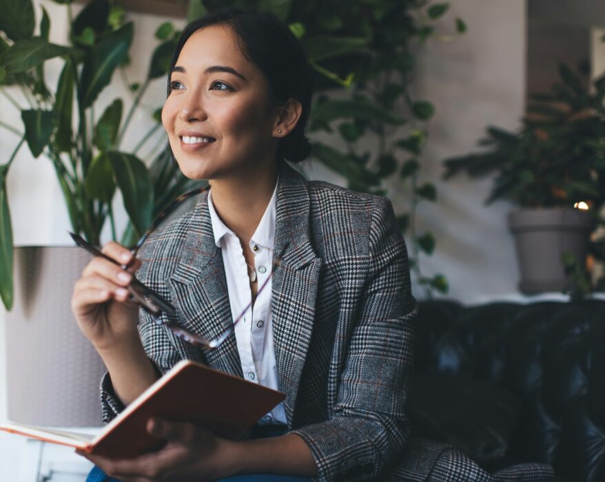 , happy Asian journalist with notepad planning